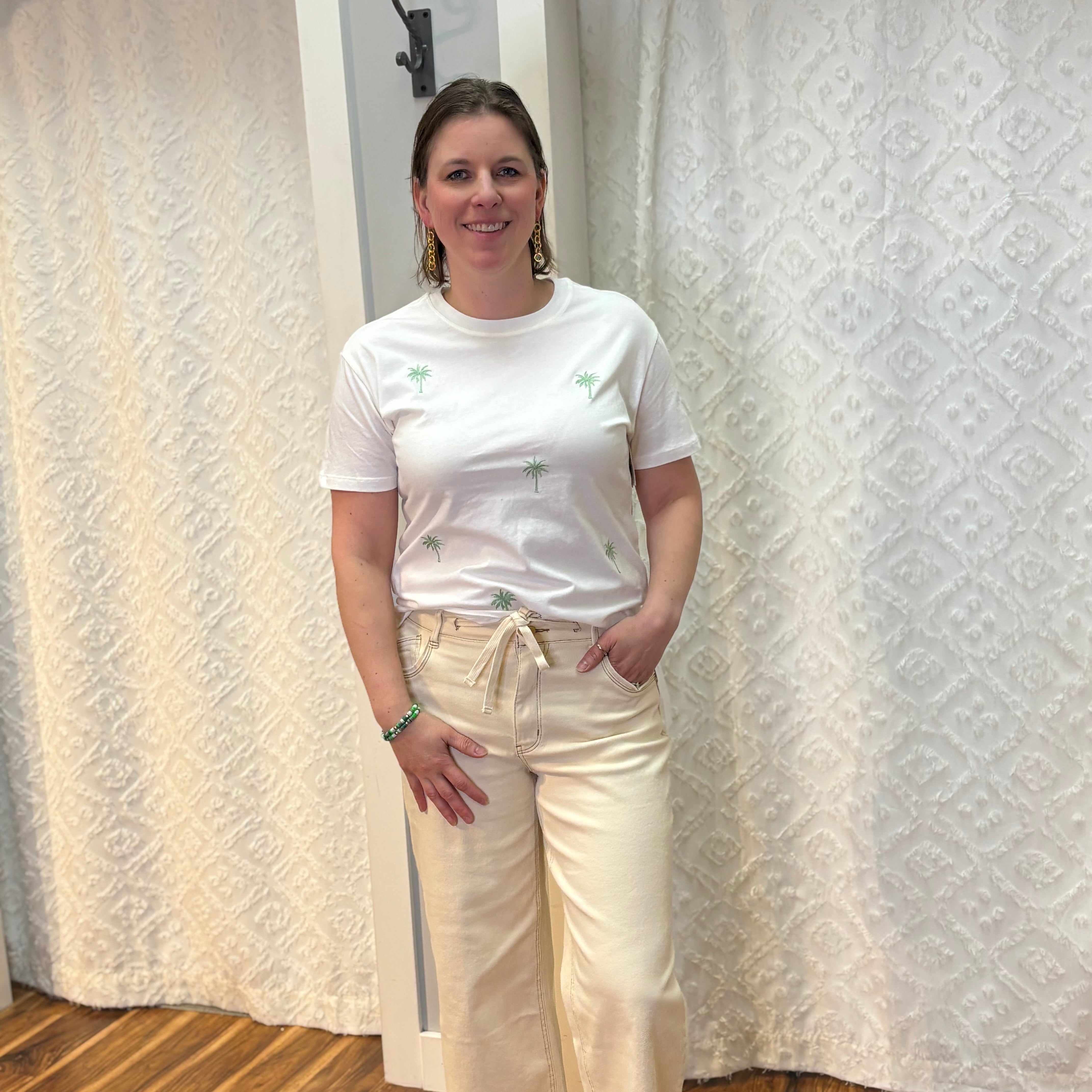Woman wearing white boyfriend-fit tee shirt with green palm trees pattern