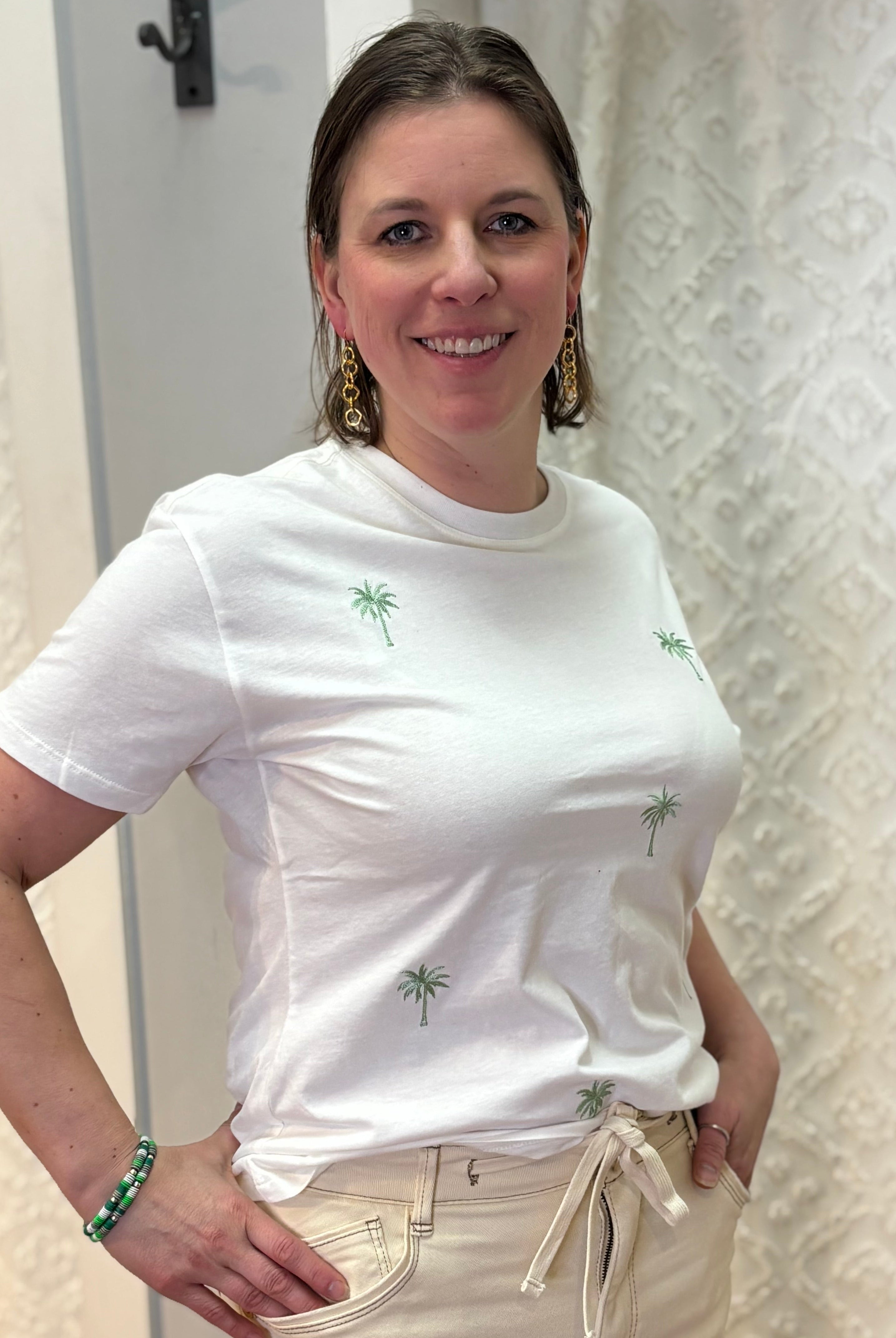 Woman wearing white boyfriend-fit tee shirt with green palm trees pattern