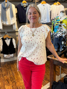 Woman in a store wearing a white blouse with red flowers