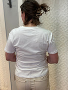 Woman wearing white boyfriend-fit tee shirt with green palm trees pattern on front